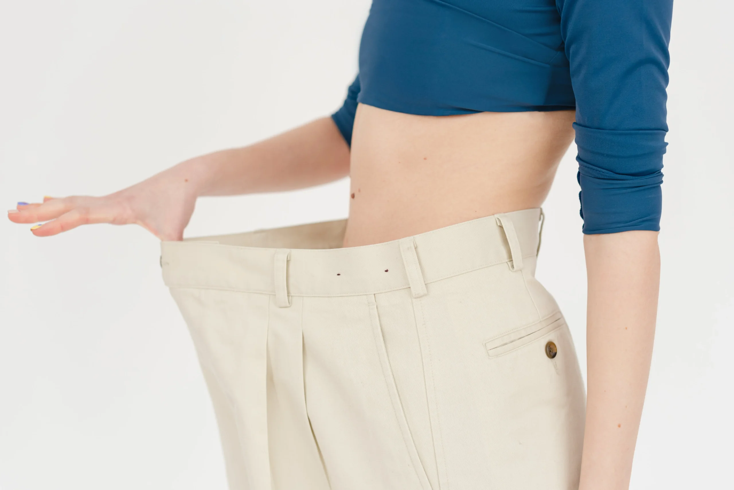 Frequently Asked Questions on Semaglutide - Woman holding out pants that are too big on her