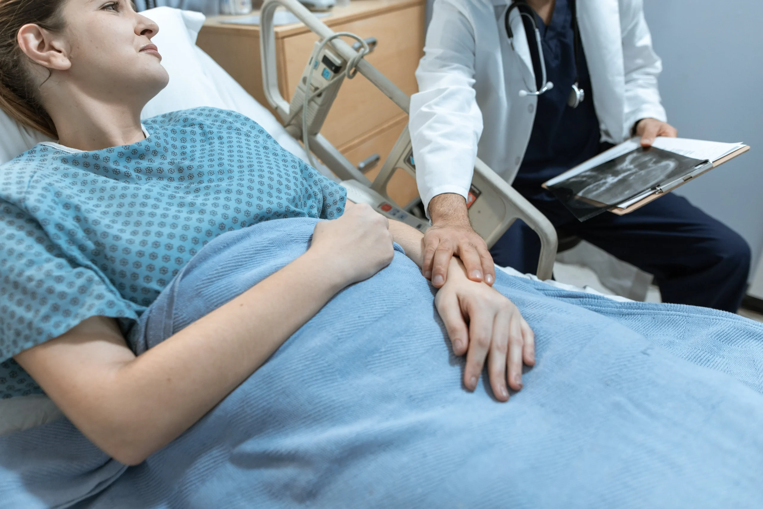 Know Your Numbers In Healthcare - doctor reading results to patient laying in hospital bed