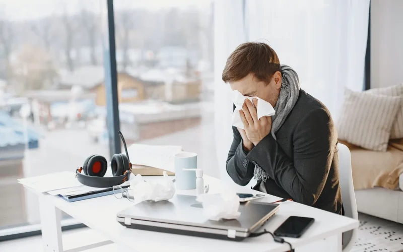 Difference between a cold - man sitting in office blowing his nose